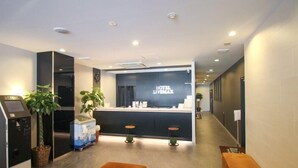 A hotel reception area with a modern design, featuring a reception desk, seating area, and a self-service kiosk. - Hotel Live Max Nagoya Sakuradoriguchi (Nagoya)