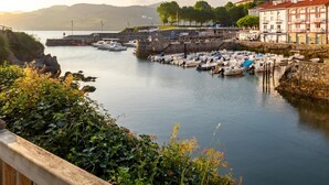 Un puerto con barcos amarrados, un muro de piedra y edificios con balcones.