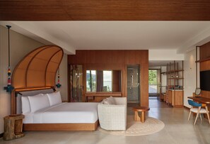 A modern bedroom with a large bed, a sitting area, a desk, and a view of the outside. - Canopy by Hilton Seychelles (Mahé Island)