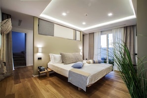 A modern bedroom with a bed, bedside tables, and a view of the outdoors. - Noha Lifestyle - Adults Only (Pula)