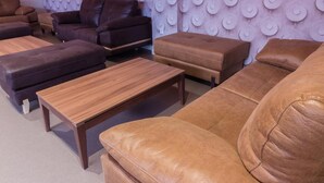 A modern living room with leather sofas, a wooden coffee table, and a patterned wall. - Hotel Novo Candido (Ourense)