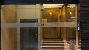 A hotel entrance with a modern design, featuring a glass door, a staircase leading inside, and a sign above the door. - Hotel Novo Candido (Ourense)