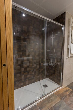A glass-enclosed shower with a tiled wall and a wooden door frame. - Hotel Novo Candido (Ourense)