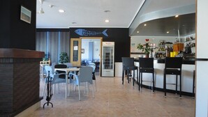A restaurant interior with a bar area, dining tables, and chairs. - Hotel Marina (Oropesa del Mar)