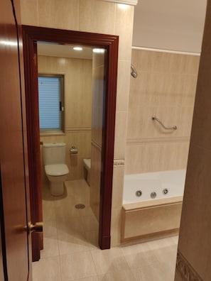 Une salle de bain comprenant des toilettes, un lavabo et une baignoire.