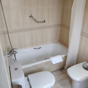 A bathroom with a bathtub, toilet, and shower area. - Hotel Chef Rivera (Padron)