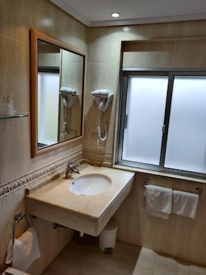 A bathroom with a sink, mirror, hairdryer, and towel rack. - Hotel Chef Rivera (Padron)