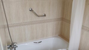 Un baño con bañera, inodoro y ducha.