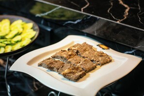 Une assiette de nourriture sur une assiette blanche, avec un plan de travail en marbre noir en arrière-plan.
