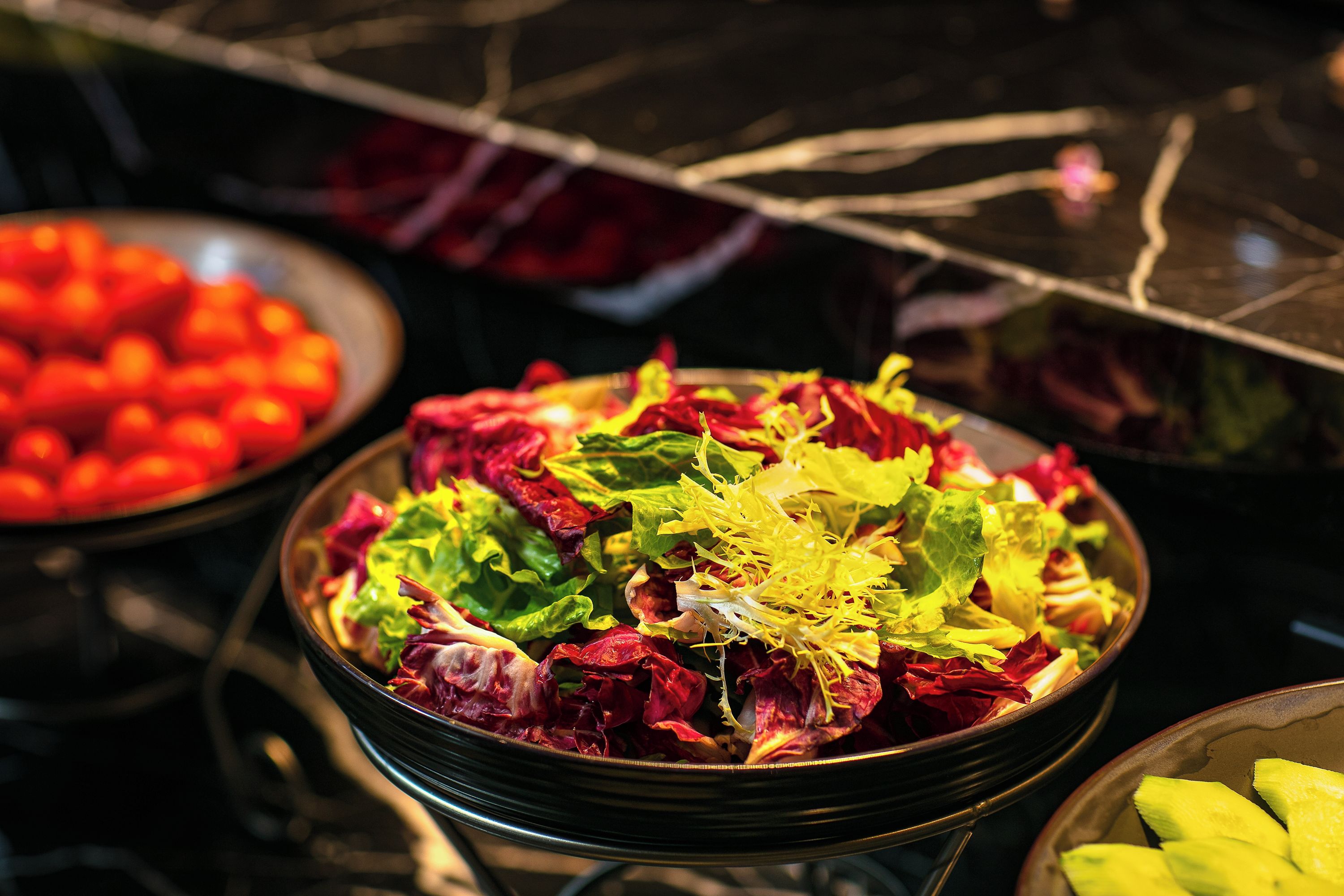 A salad bowl with various greens and vegetables.