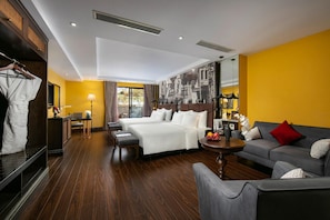 Een hotelkamer met een bed, een bank, een bureau en een kledingkast.