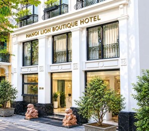Een gebouw met de tekst 'HANOI LION BOUTIQUE HOTEL' en grote ramen.