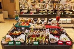 A buffet with various food items and beverages, including salads, fruits, and hot dishes. - Red Fox Hotel, Alwar (Alwar)