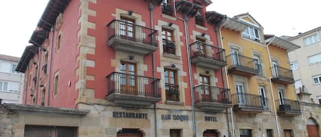 A multi-story building with a restaurant on the ground floor, a hotel on the second floor, and balconies with railings.