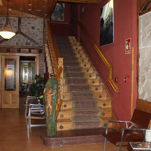 A staircase with wooden steps and a handrail, leading to a higher floor. - Hotel San Roque (Reinosa)