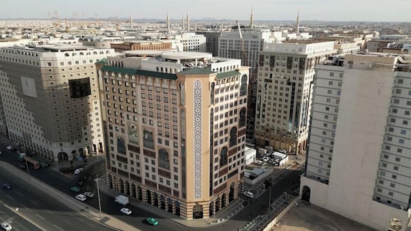 Un immeuble de grande hauteur doté d’une façade remarquable, de nombreuses fenêtres et d’un élément décoratif central.