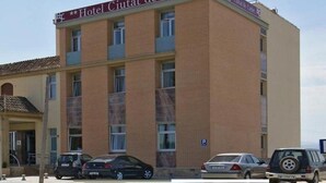 Un edificio de varios pisos con un letrero que dice 'Hotel Ciutat de Carlet'.