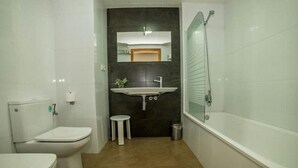 Un baño con inodoro, lavamanos y bañera.