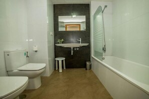 Un baño con inodoro, lavamanos y bañera.