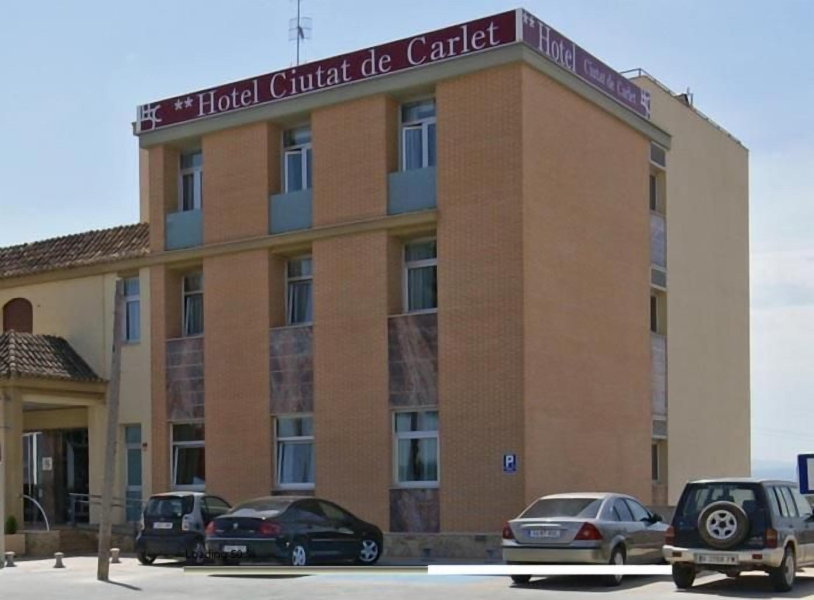 A multi-story building with a sign reading "Hotel Ciutat de Carlet."