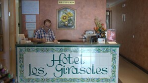 Un mostrador de recepción en el Hotel Los Girasoles con un cartel que indica la zona de recepción.