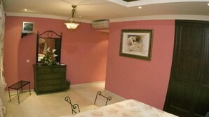 Un dormitorio con cama, cómoda, espejo y un cuadro en la pared.