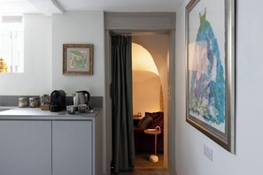 Una cocina moderna con cafetera, hervidor y frascos sobre la encimera.