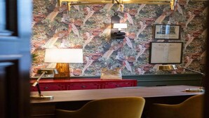 A room with a patterned wallpaper, a desk with two chairs, a lamp, and a red cabinet. - The White Hart Hotel Lincoln (Lincoln)