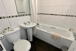 Une salle de bain avec des toilettes, un lavabo et une baignoire.