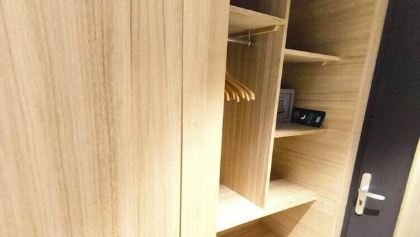 Un armadio in legno con ripiani multipli e una porta.