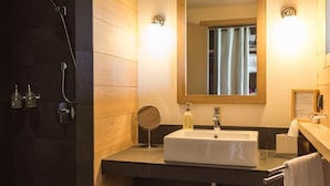 Un bany modern amb un mirall gran, un lavabo i una dutxa.