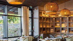 Interior de restaurant amb cadires de vimet, taula de fusta i llumferes penjades de vimet.