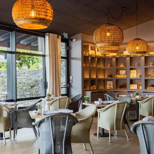 A restaurant interior with wicker chairs, a wooden table, and hanging wicker lamps. - Relais Du Silence La Gree Des Landes Eco Hotel Spa Yves Rocher (Cournon)
