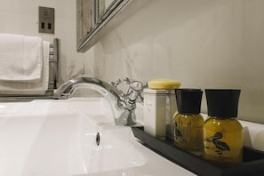 A bathroom with a white sink, a chrome faucet, a mirror, a towel rack, and two bottles of Duck Island body wash. - Leighinmohr House Hotel (Ballymena)