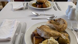 A dining table with plates of food, cutlery, and a salt and pepper set. - The Lanes Hotel (Brighton)