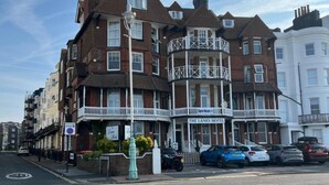 A multi-story hotel with a prominent balcony, a sign reading 'The Lanes Hotel,' and several parked cars on the street. - The Lanes Hotel (Brighton)