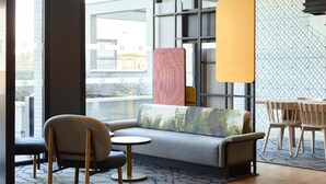 A modern lounge area with a sofa, chairs, and a small table. - B&B Hotel Le Port Marly Saint Germain en Laye (La Haute-Maison)