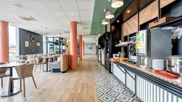 A modern cafe interior with a long counter, seating area, and a patterned floor.