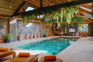 An indoor swimming pool with stone walls, wooden beams, and hanging plants. - Lanelay Hall Hotel and Spa (Pontyclun)