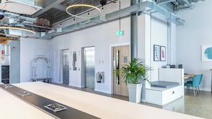 A modern office space with a reception desk, elevators, and a plant. - Holiday Inn Sunderland, an IHG Hotel (Sunderland)