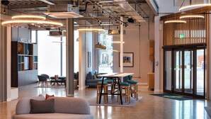 A modern interior with a curved sofa, a dining area, and a reception desk. - Holiday Inn Sunderland, an IHG Hotel (Sunderland)