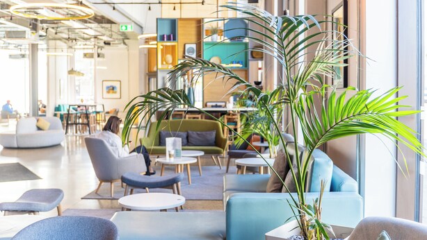 A modern lounge area with seating arrangements, a coffee table, and a large potted plant. - Holiday Inn Sunderland, an IHG Hotel (Sunderland)