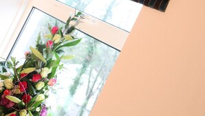 A window with a striped valance and a floral arrangement. - Greenvale Hotel (Cookstown)