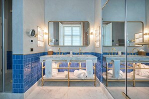 A bathroom with two sinks, a large mirror, and blue-tiled walls. - Palacio Ludovice (Lisbon)