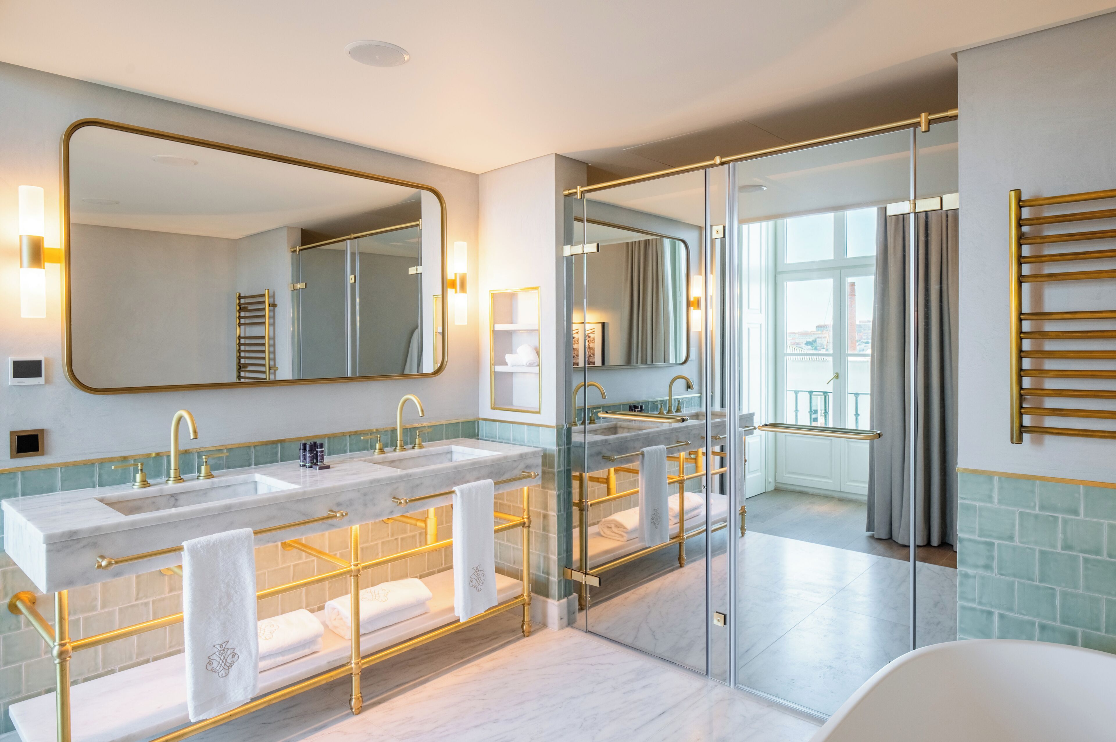 A modern bathroom with dual sinks, a large mirror, and a glass shower enclosure.