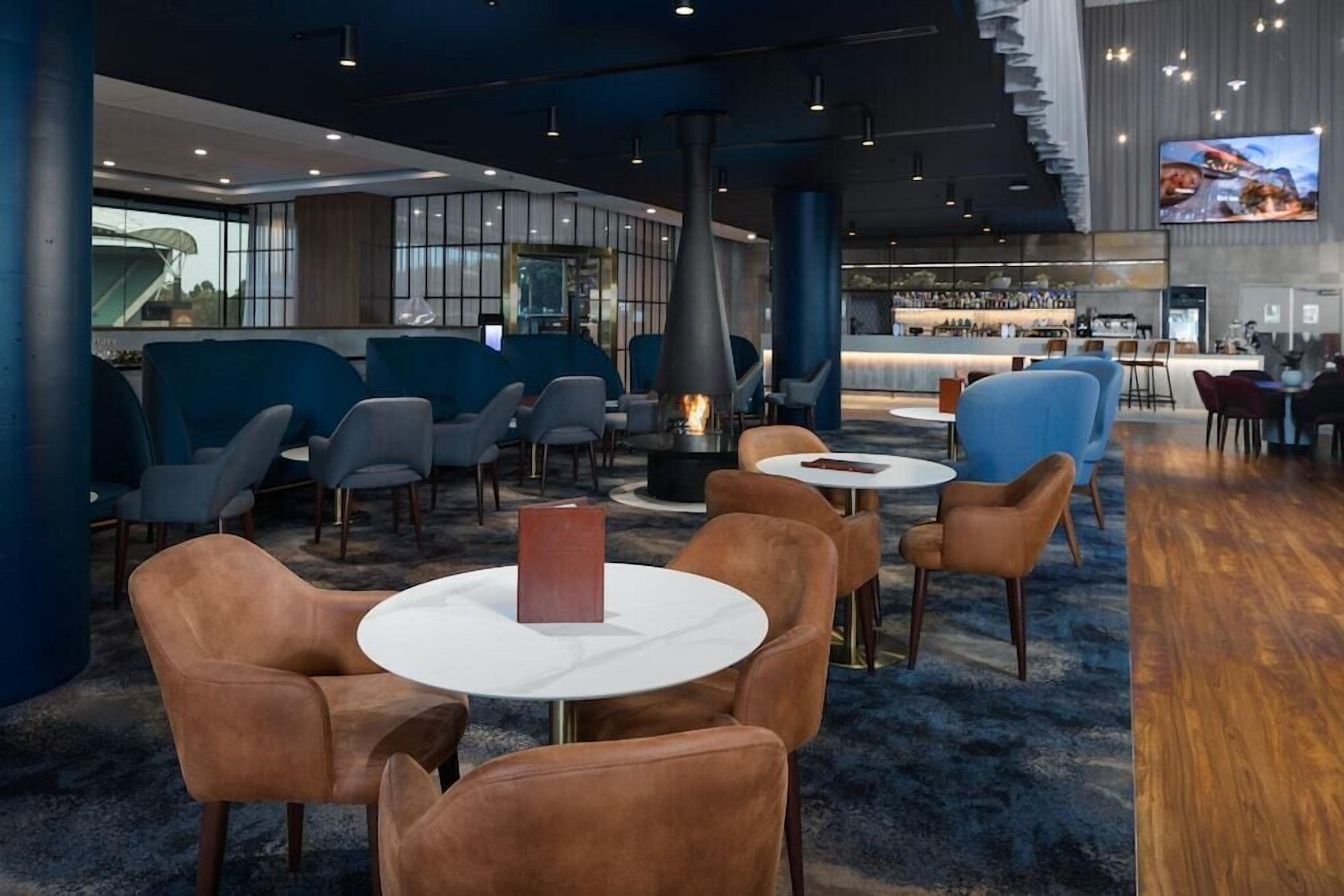 A modern lounge area with seating, a bar, and a fireplace.