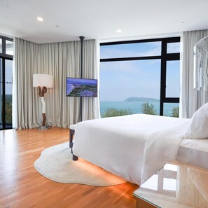 A modern hotel room with a large bed, a flat-screen TV mounted on the wall, and a view of the sea. - The Riyaz Lavanya (Langkawi)