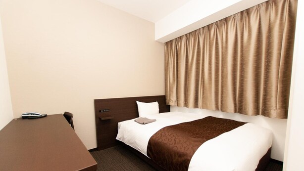 A hotel room with a bed, a desk, and a telephone. - Ai Hotel Hashimoto (Sagamihara)