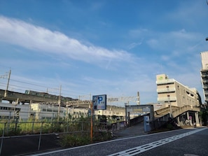 A parking sign with a pedestrian bridge and a train track overhead. - Ai Hotel Hashimoto (Sagamihara)