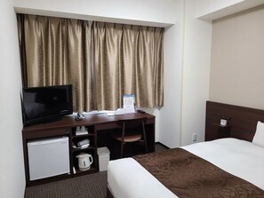 A hotel room with a bed, a desk with a television, a small refrigerator, a kettle, and a clock on the nightstand. - Ai Hotel Hashimoto (Sagamihara)